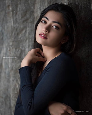 Rashmika Mandanna Elegant Portrait Against Textured Stone Wall HD phone wallpaper