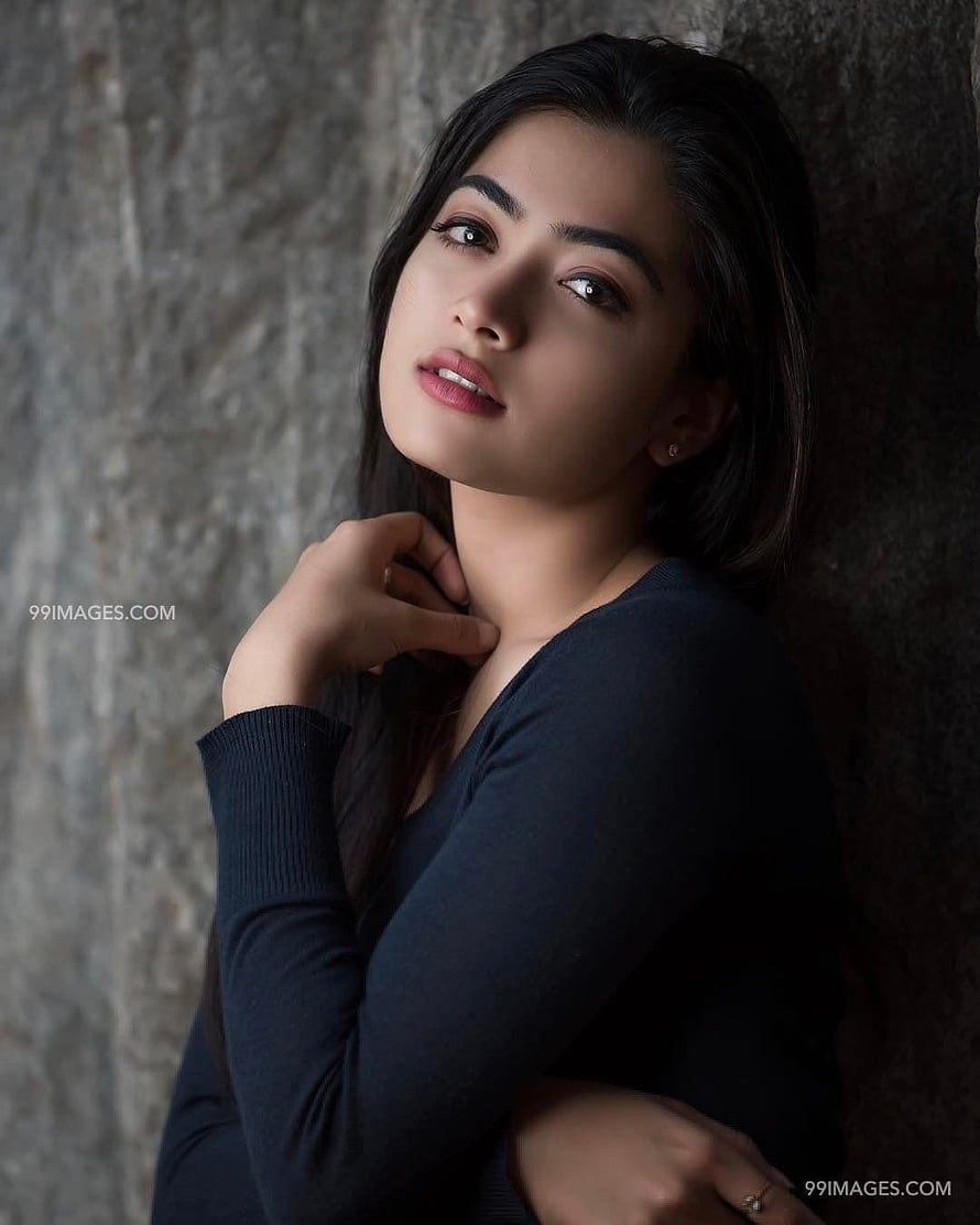 Rashmika Mandanna Elegant Portrait Against Textured Stone Wall HD phone wallpaper