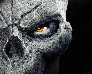 Close-Up of a Cracked Stone Skull with a Glowing Red Eye in Dark Horror Style HD wallpaper