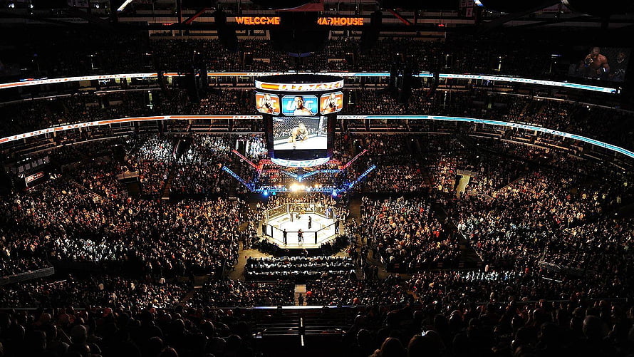 UFC Octagon Arena with Massive Crowd and Central Jumbotron Display HD wallpaper