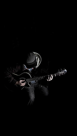 Moody Black and White Portrait of a Guitarist Playing an Acoustic Guitar in Low Light HD phone wallpaper