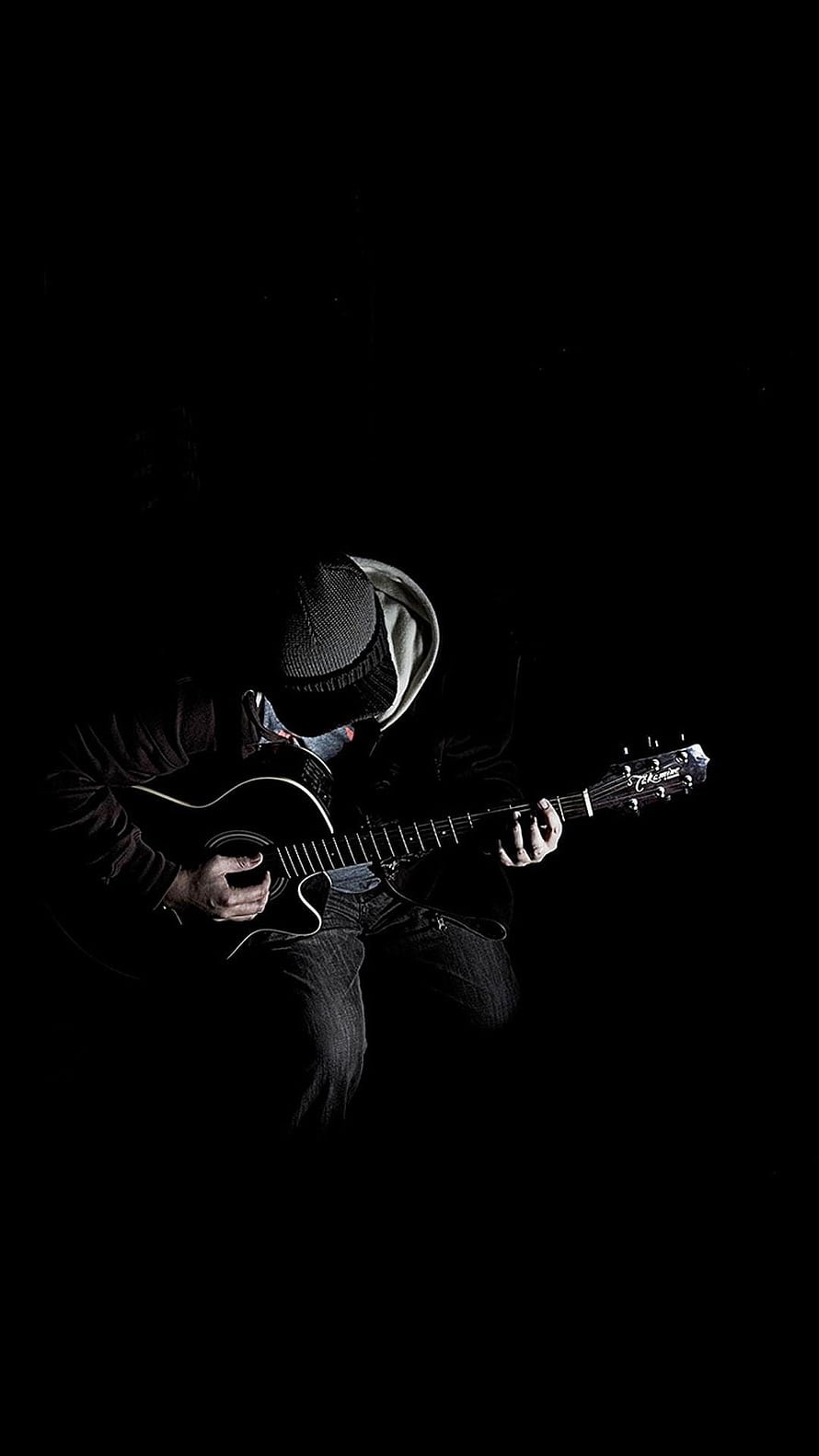 Moody Black and White Portrait of a Guitarist Playing an Acoustic Guitar in Low Light HD phone wallpaper