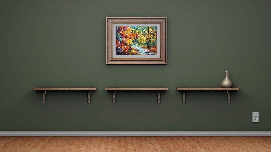 Minimalist interior with floating wooden shelves and framed autumn landscape painting on a dark green wall HD wallpaper