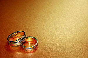 Elegant Gold Wedding Bands on Textured Surface HD wallpaper