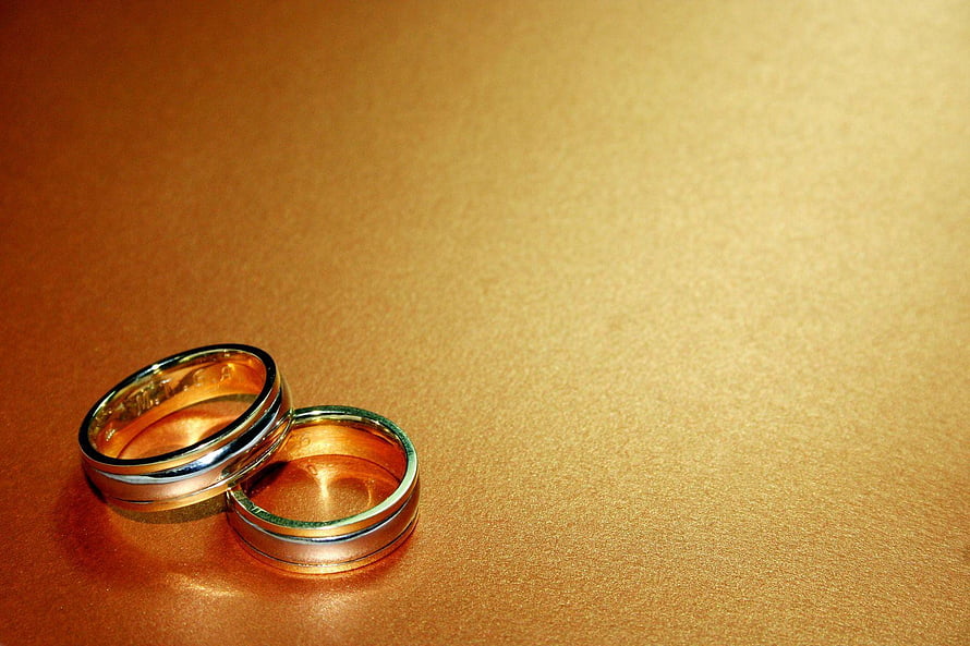 Elegant Gold Wedding Bands on Textured Surface HD wallpaper