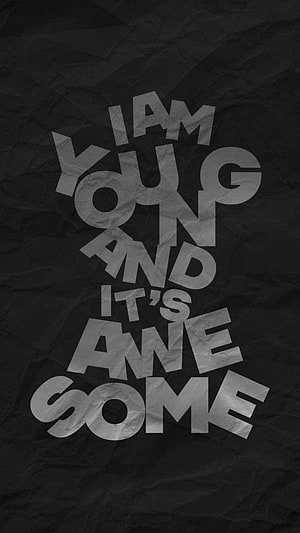 I Am Young And It's Awesome Bold Typography on Crumpled Black Paper Background HD phone wallpaper