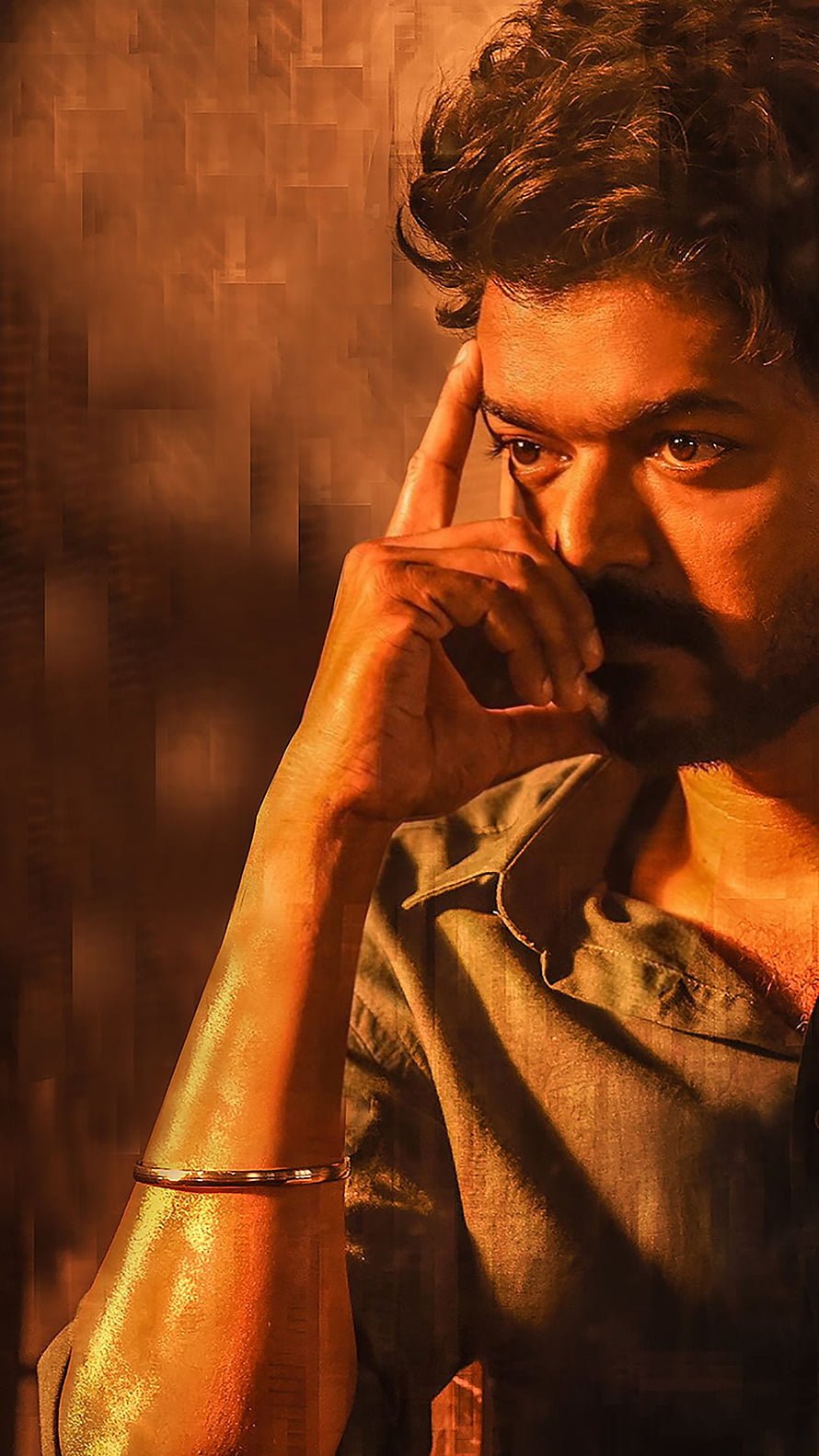 Thalapathy Vijay in a moody contemplative portrait with warm amber lighting and textured background HD phone wallpaper
