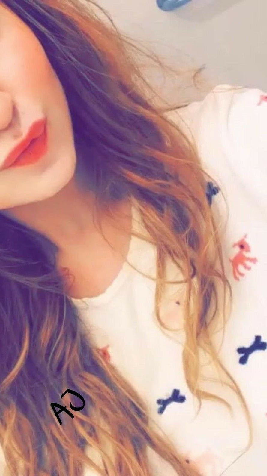 Close-up portrait of a woman with long wavy hair and red lipstick lying on a patterned white shirt HD phone wallpaper