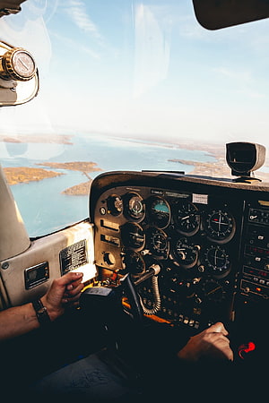 Pilot's Hands on Cessna Cockpit Instruments Flying Over Coastal Islands HD phone wallpaper