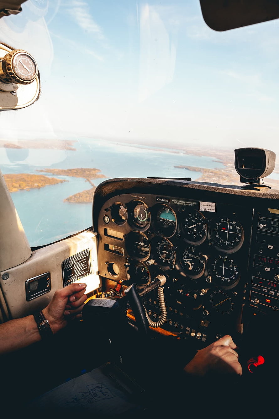 Pilot's Hands on Cessna Cockpit Instruments Flying Over Coastal Islands HD phone wallpaper