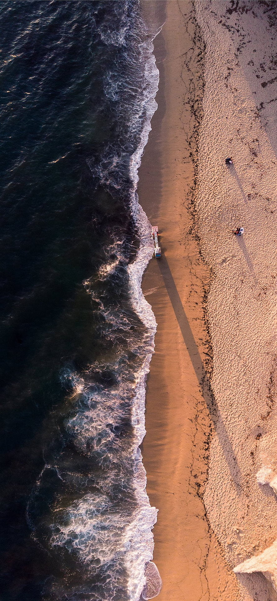 Aerial View of Ocean Waves Meeting a Sandy Beach at Golden Hour HD phone wallpaper