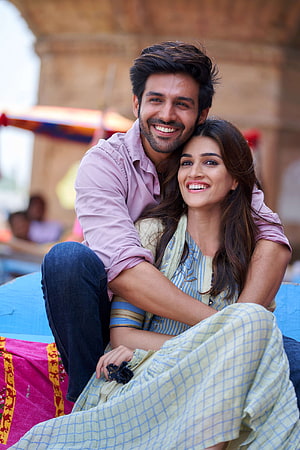 Kartik Aaryan and Kriti Sanon Share a Warm Embrace in Vibrant Traditional Attire HD phone wallpaper