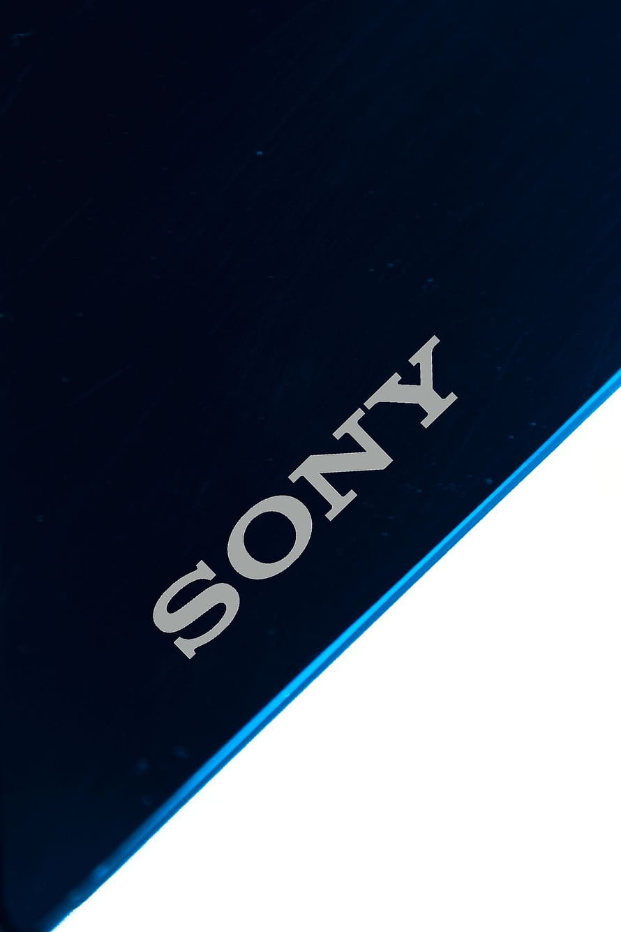 Sony Xperia Smartphone Logo Close-Up on Dark Blue Surface HD phone wallpaper