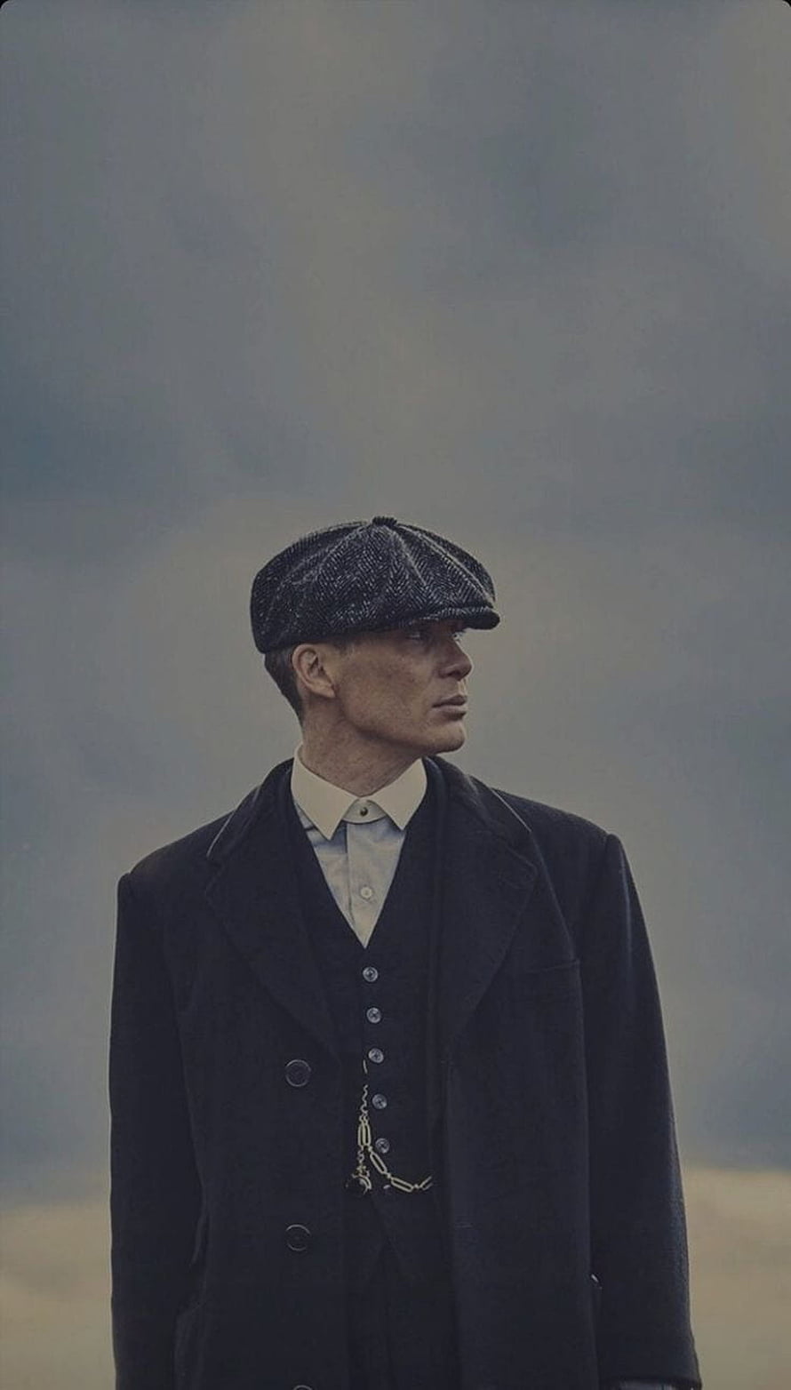 Tommy Shelby in Peaky Blinders Flat Cap and Dark Overcoat Against Misty Sky HD phone wallpaper