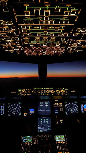 Airplane Cockpit View at Sunset with Illuminated Flight Instruments and Control Panels HD phone wallpaper