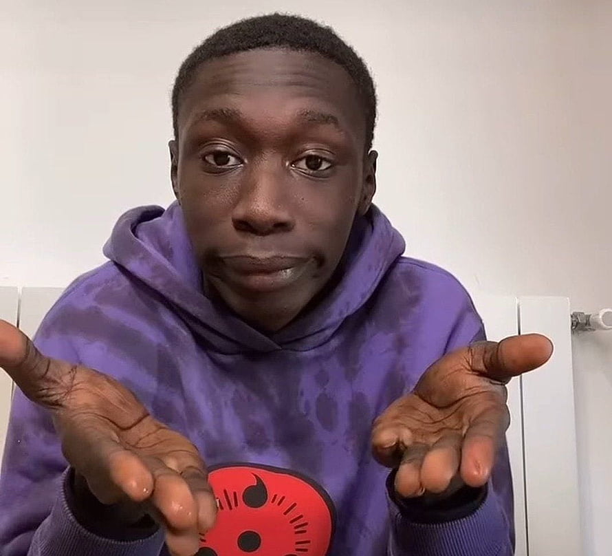 Khaby Lame in purple hoodie with expressive open hands gesture HD wallpaper