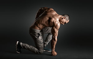 Muscular Male Athlete in Dynamic Back Pose with Defined Biceps and Camouflage Pants HD wallpaper