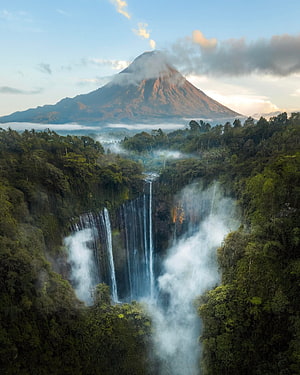 Tumpak Sewu Waterfall and Mount Semeru Rising from Misty Jungle Canopy HD phone wallpaper