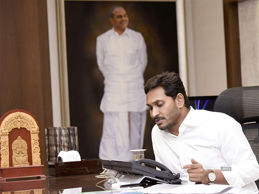 YS Jagan Mohan Reddy at desk in formal office setting with portrait in background HD wallpaper