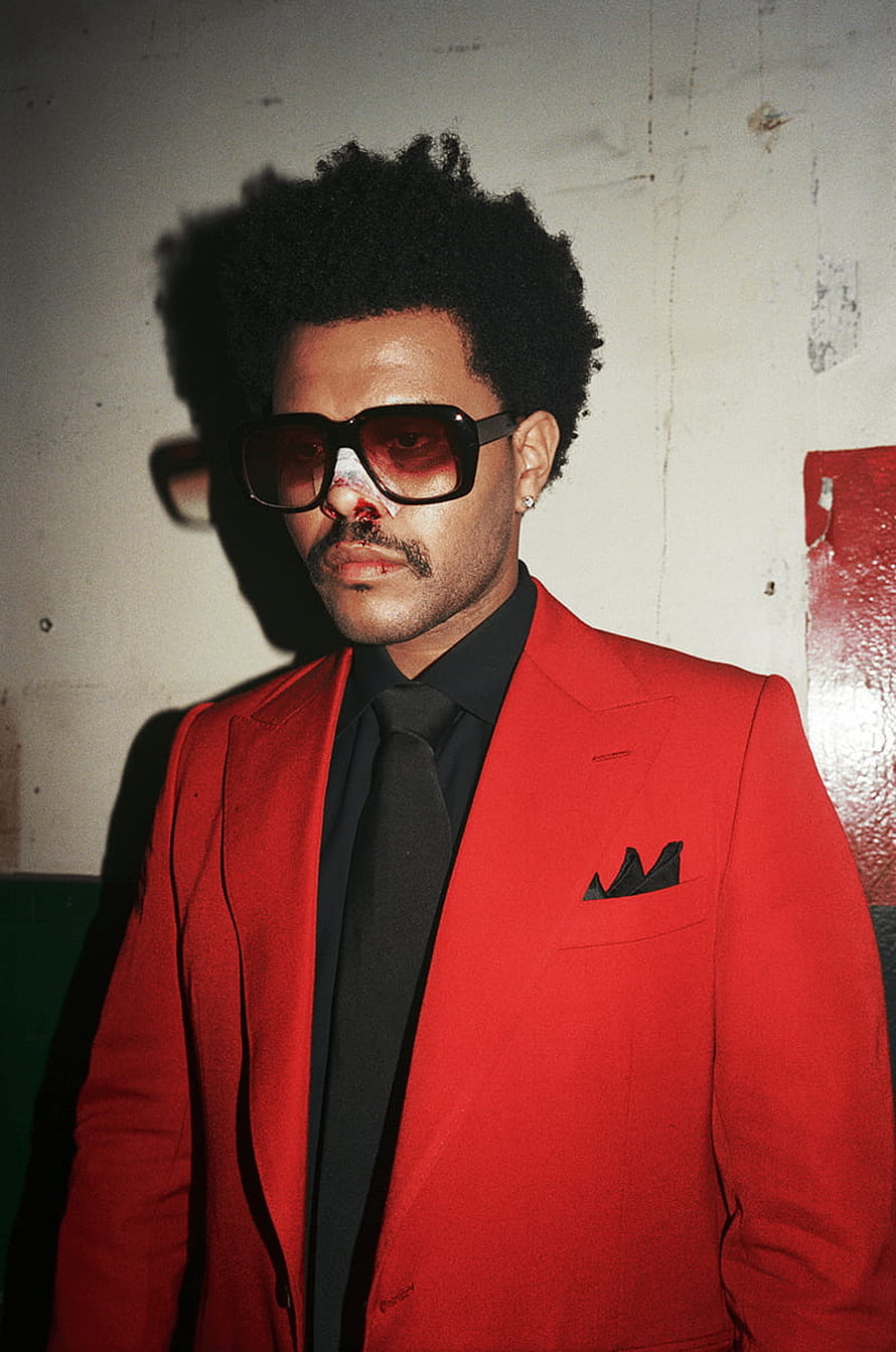 The Weeknd in a red suit with dark sunglasses and a nosebleed against a distressed wall HD phone wallpaper