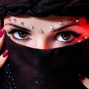 Close-up portrait of a woman in a black niqab with rhinestone face gems and dramatic eye makeup HD phone wallpaper