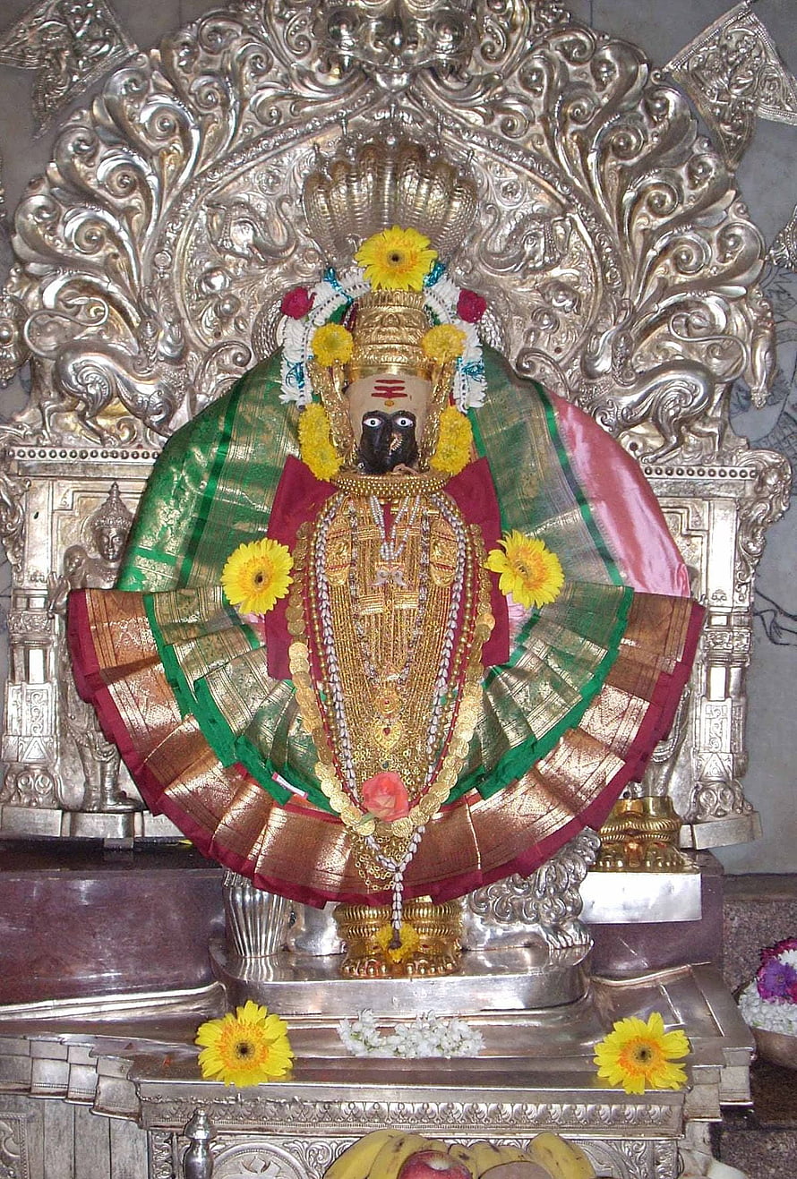 Ornate Mahalaxmi Deity Adorned With Marigold Garlands And Silver Temple Backdrop HD phone wallpaper