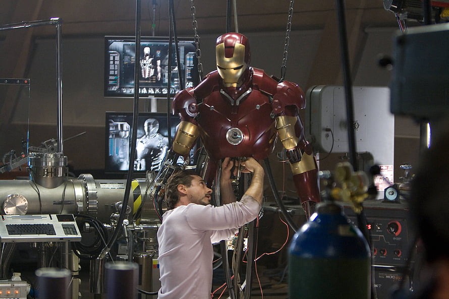 Tony Stark Assembling The Iron Man Armor In A High-Tech Workshop HD wallpaper