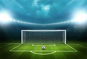 Illuminated Soccer Goal and Ball on a Green Pitch Under Stadium Floodlights HD wallpaper