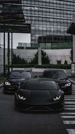 Black Lamborghini Huracan and BMW M4 Supercars Parked in Urban Setting HD phone wallpaper