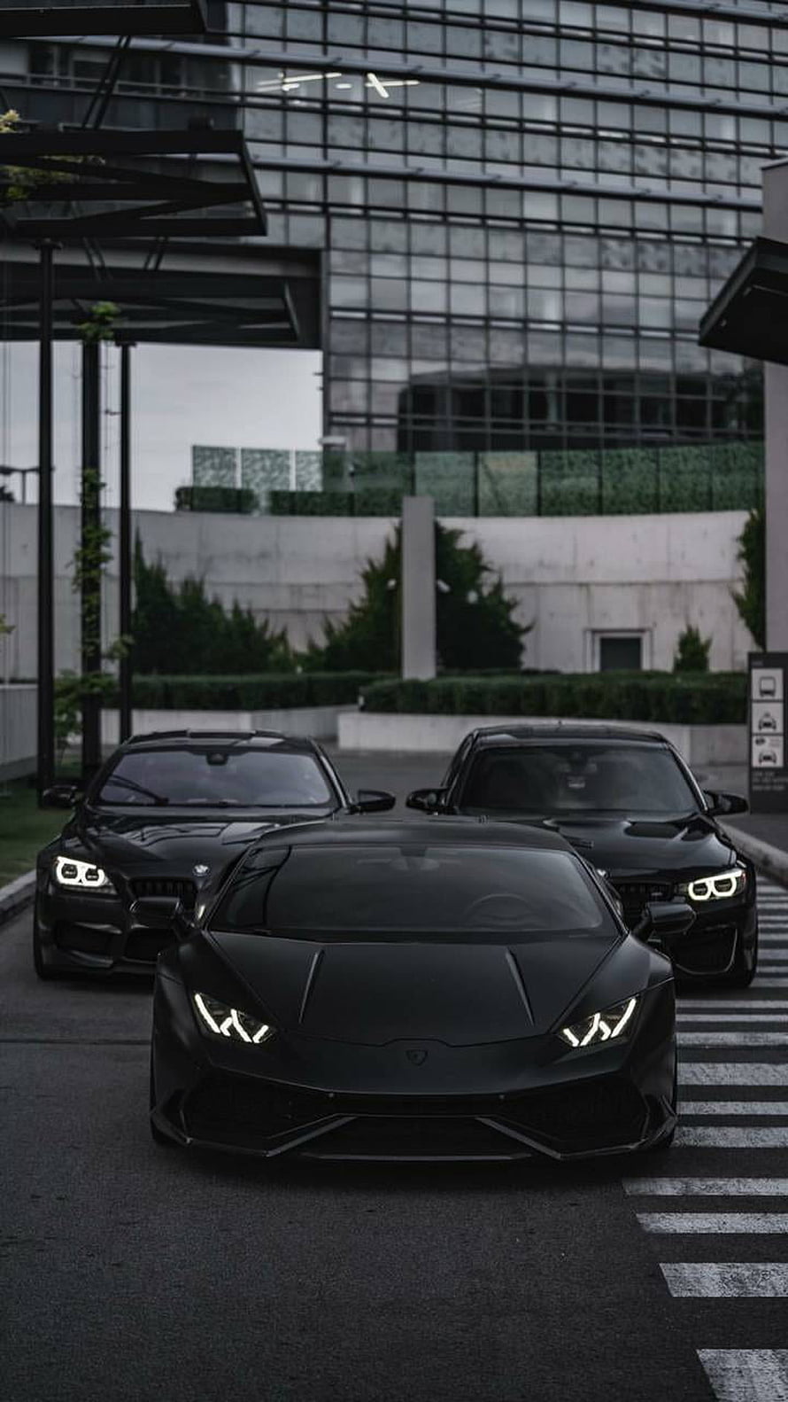 Black Lamborghini Huracan and BMW M4 Supercars Parked in Urban Setting HD phone wallpaper
