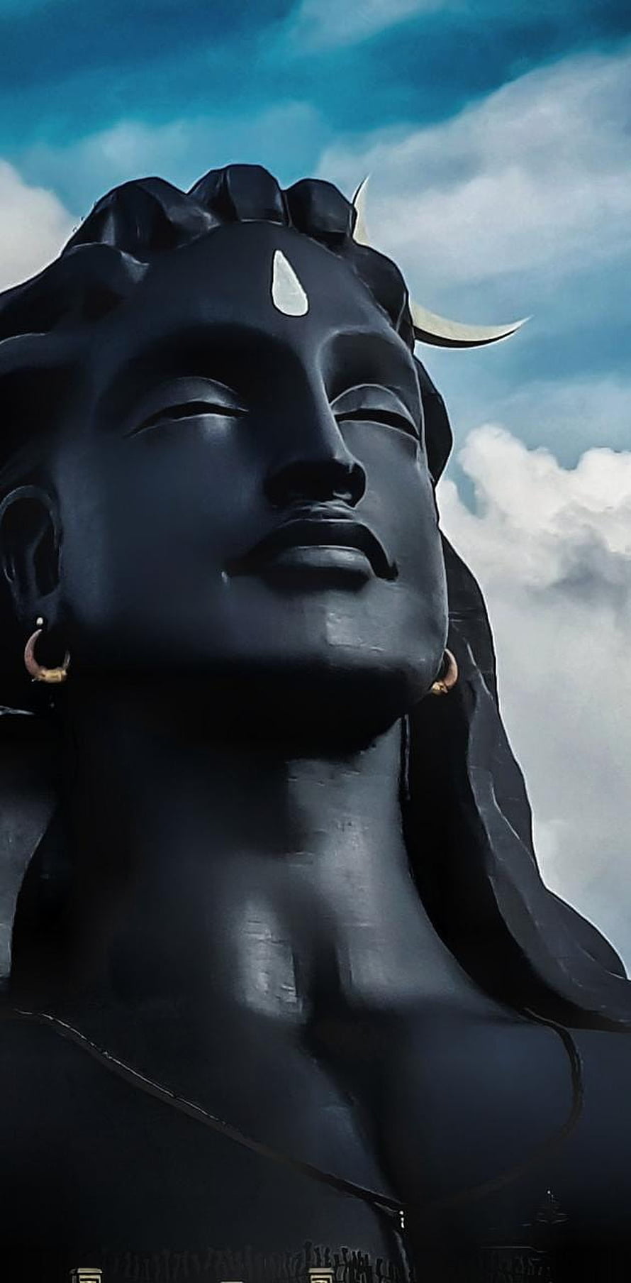 Adiyogi Statue Portrait with Crescent Moon and Serene Expression Against Cloudy Sky HD phone wallpaper