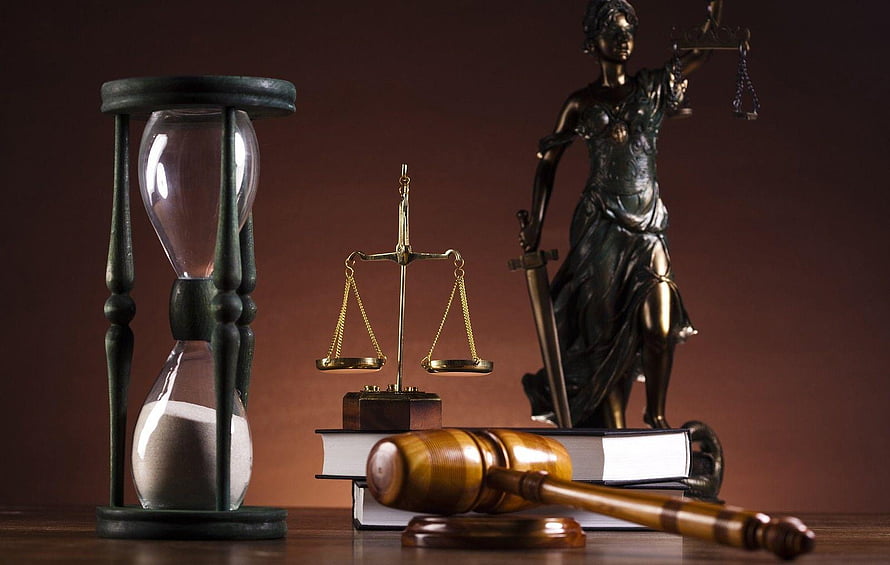 Lady Justice statue with scales, gavel, law books, and hourglass on a dark background HD wallpaper