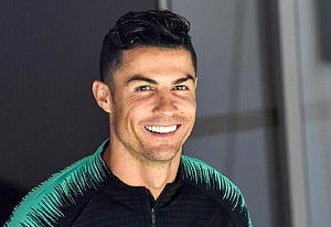 Cristiano Ronaldo smiling portrait in a black and teal athletic jacket HD wallpaper