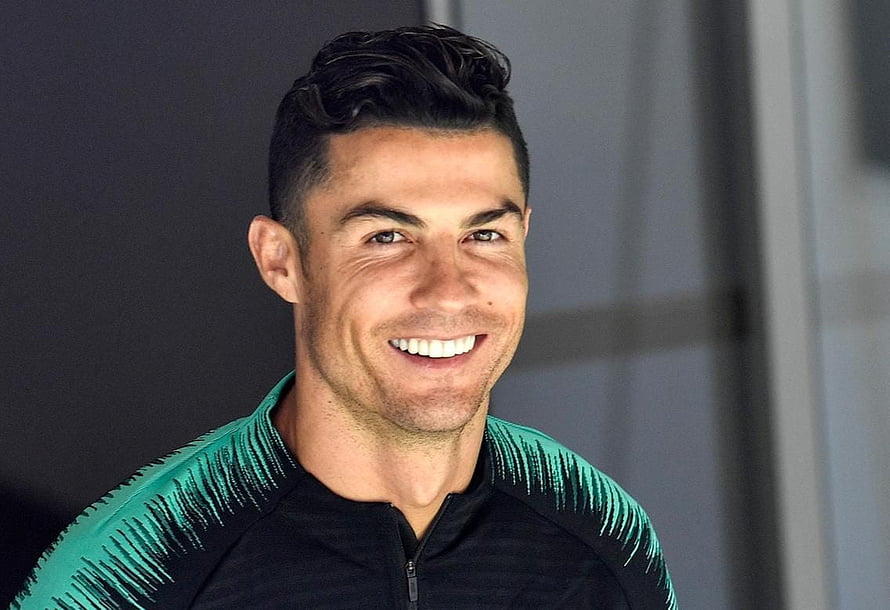 Cristiano Ronaldo smiling portrait in a black and teal athletic jacket HD wallpaper