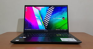 ASUS VivoBook 15 OLED Laptop with Vibrant Display on Wooden Desk HD wallpaper