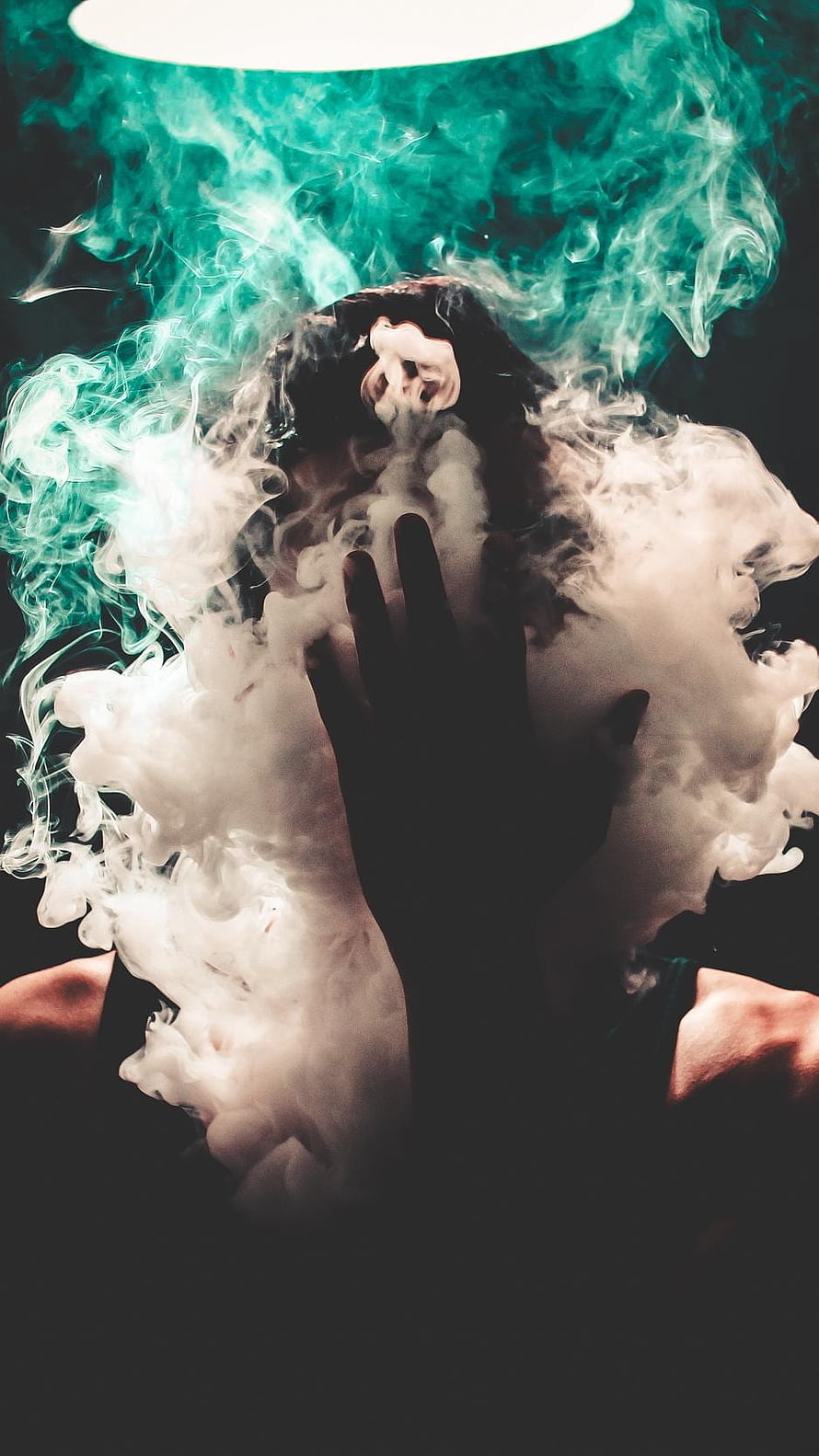 Mysterious Portrait of a Woman with Hands Over Face Surrounded by Teal and White Smoke HD phone wallpaper