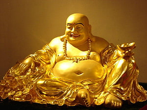 Golden Laughing Buddha Statue Holding Ingot and Coins HD wallpaper