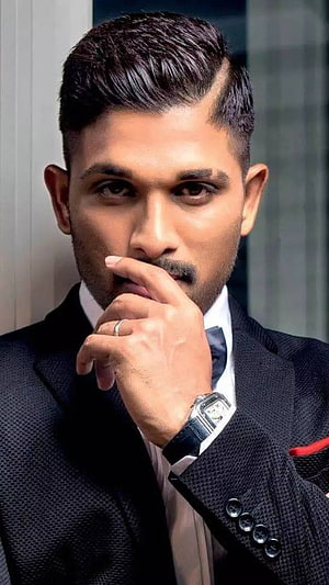 Allu Arjun in a textured dark suit with a modern side-parted hairstyle and luxury wristwatch HD phone wallpaper
