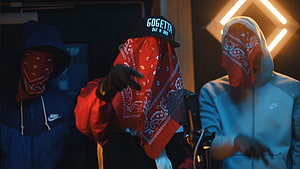 Three masked figures in bandanas and Nike hoodies performing in a neon-lit studio HD wallpaper