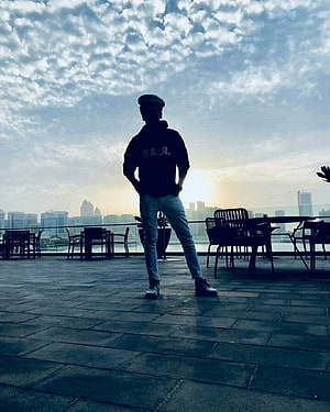 Silhouette of a man in a cap standing on a rooftop terrace overlooking a city skyline at sunset, Whatsapp DP in 2021, instagram dp boys HD phone wallpaper