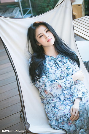 Han So Hee in a Floral Dress Reclining on a White Outdoor Lounge Chair HD phone wallpaper