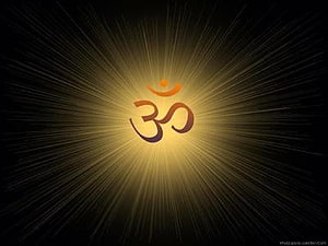 Glowing Om Symbol Radiating Golden Light on Dark Background HD wallpaper