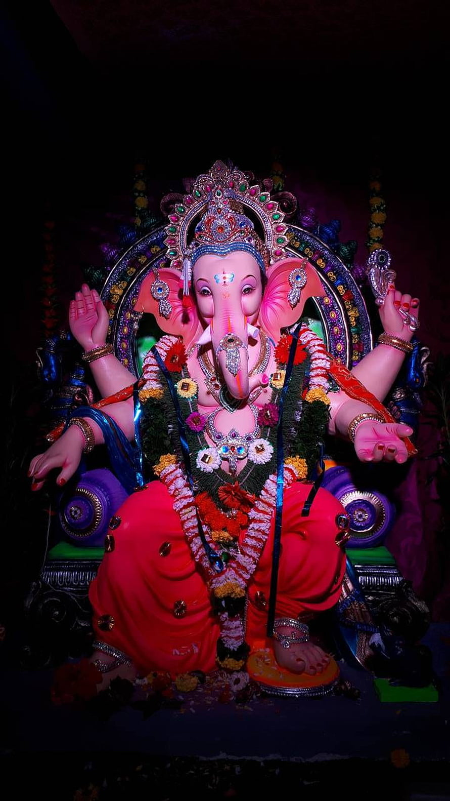 Ornate Ganesha Murti Adorned With Floral Garlands And Jewels In A Dark Temple Setting HD phone wallpaper