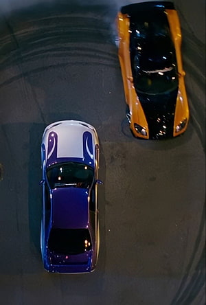 Top-Down View of Two Sports Cars Drifting on a Dark Asphalt Track at Night HD phone wallpaper