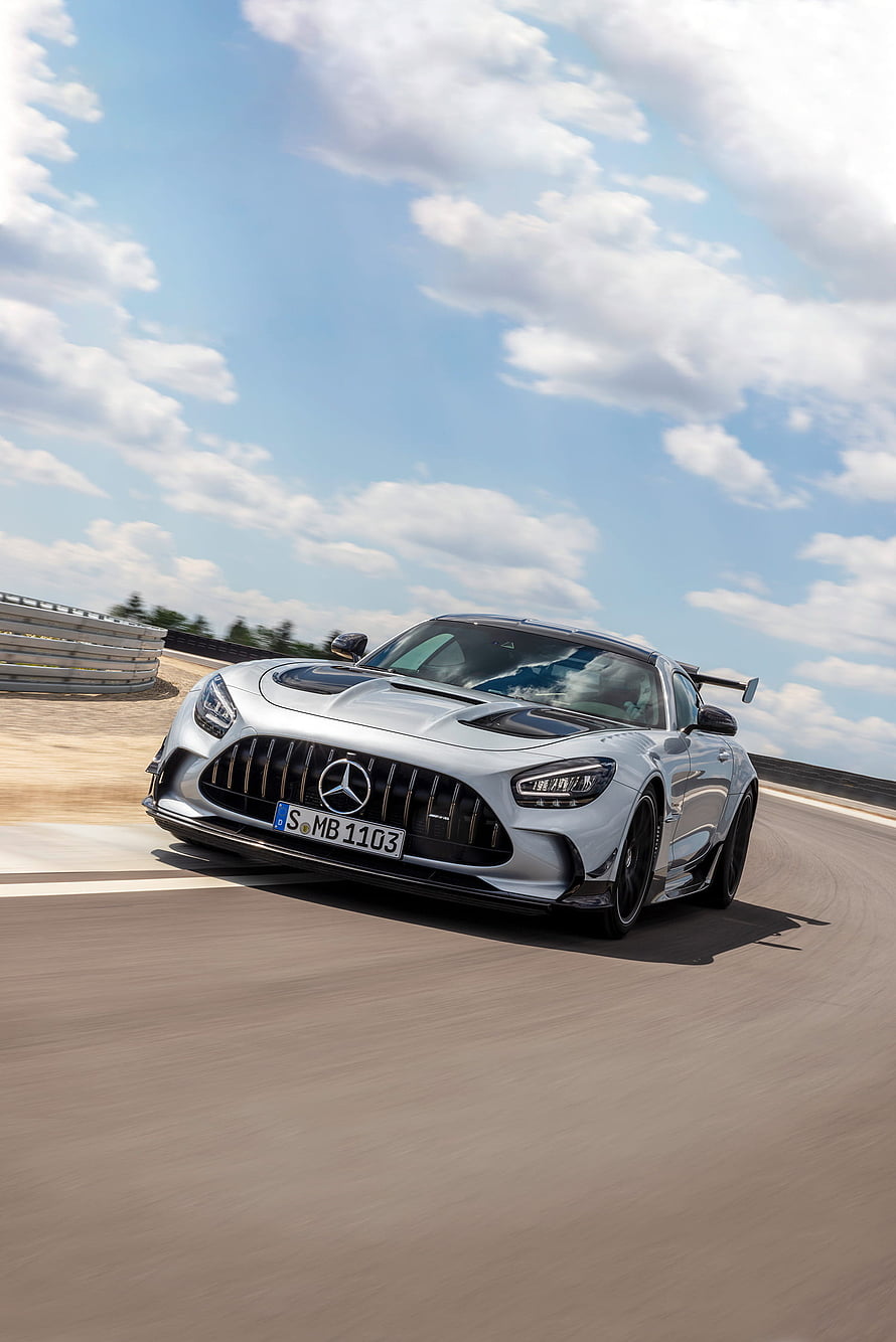 Silver Mercedes AMG GT Black Series speeding on a racetrack under a bright blue sky HD phone wallpaper