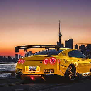 Yellow Nissan GT-R Widebody with HKS and Bride Stickers Parked at Sunset in Toronto HD phone wallpaper