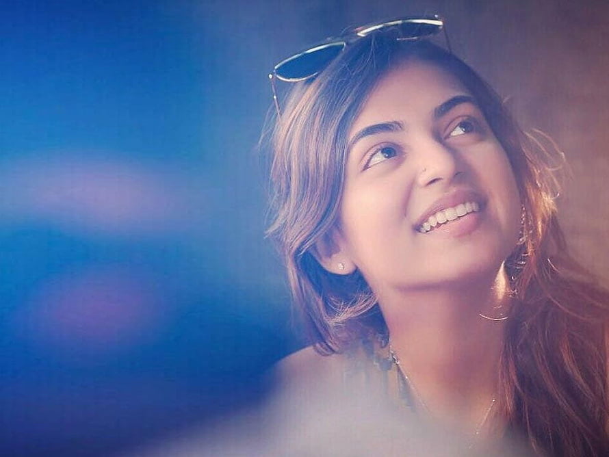 Nazriya Nazim smiling portrait with sunglasses on head against a soft blue background HD wallpaper