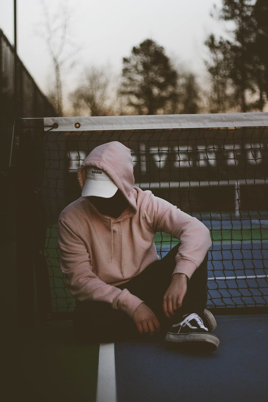 Mysterious Hooded Figure Sitting on Tennis Court Net Post HD phone wallpaper