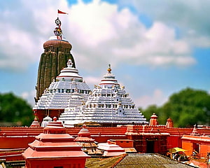 Lord Jagannath Temple Puri India with White Shikharas and Red Flag Against Blue Sky HD wallpaper