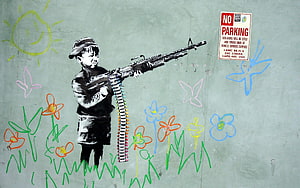 Banksy Street Art of a Boy Soldier Holding a Machine Gun Amidst Colorful Flowers and Butterflies HD wallpaper